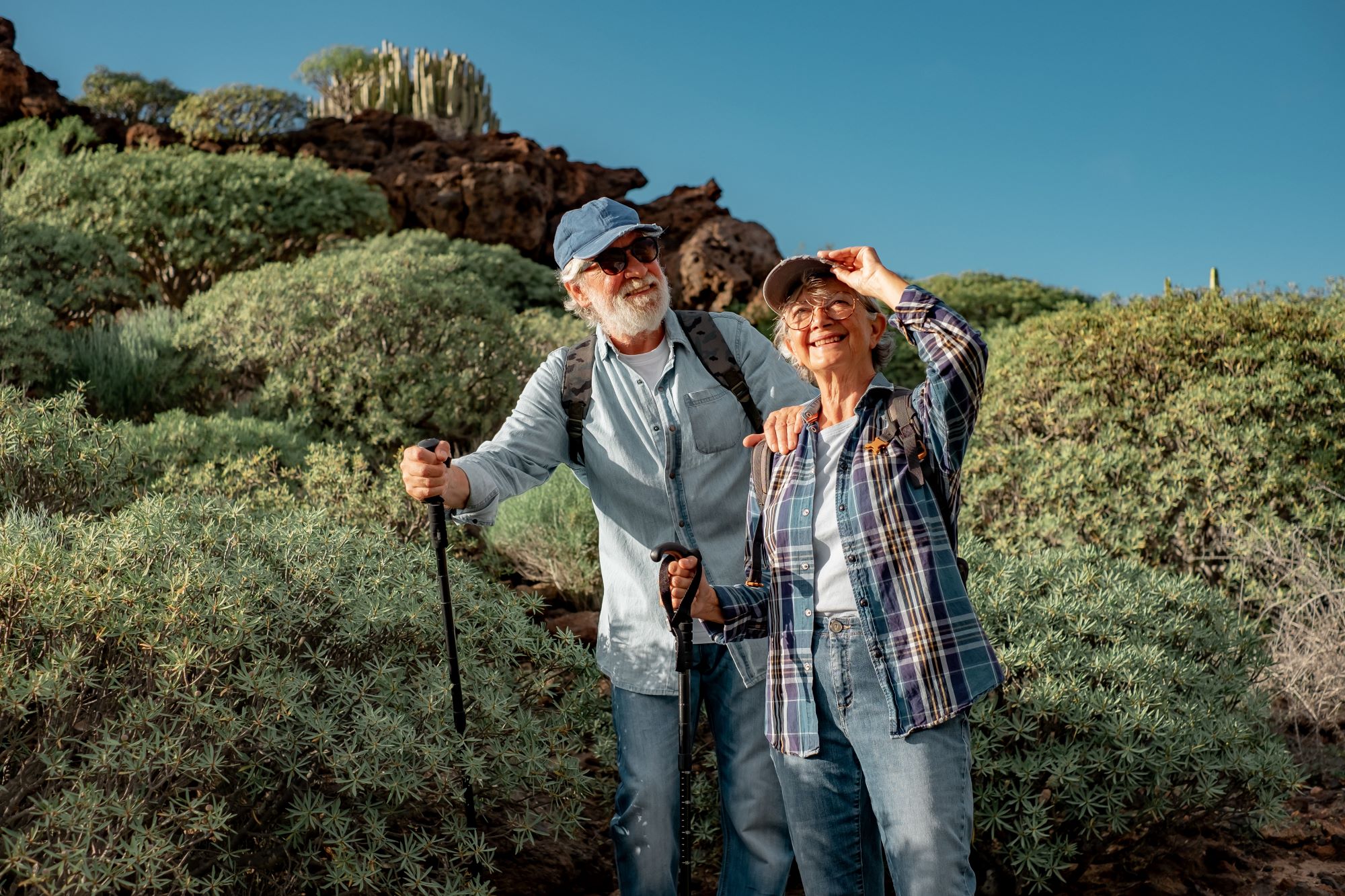 Smiling old senior couple enjoying outdoor excursion in mountain environment